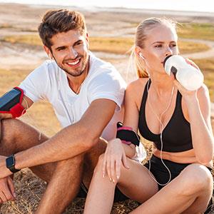 fitness singles sitting on beach after run