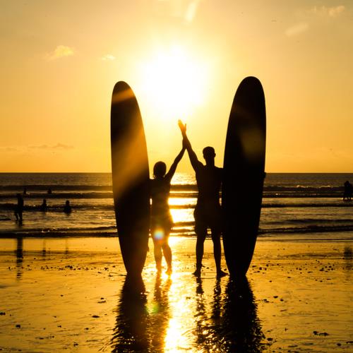 couple on beach with surf boards
