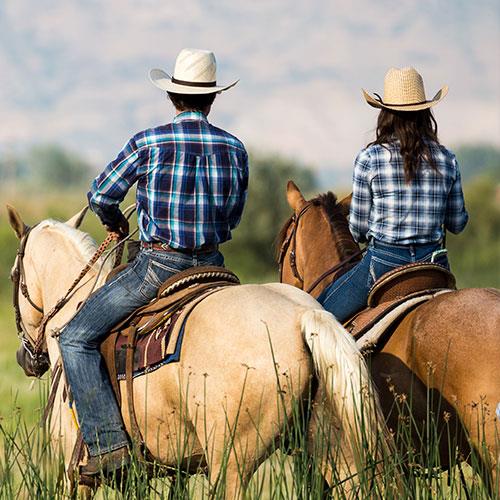 country couple ranchers, riding horses