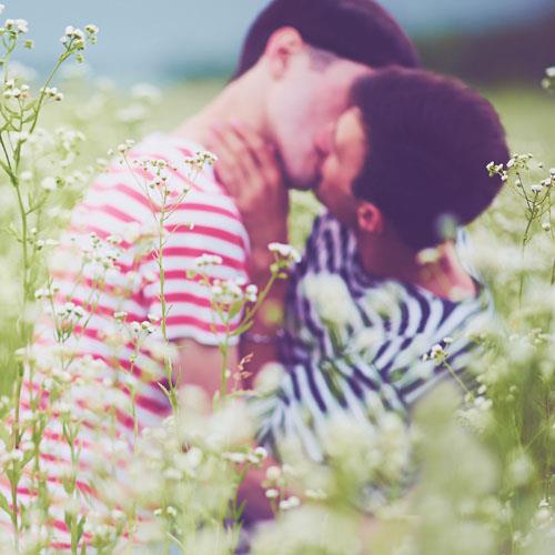 gay men kissing in a field